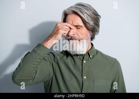 Portrait de l'attrayant fatigué déprimé malade gris-cheveux homme touchant le nez souffrant isolé sur fond gris pastel couleur Banque D'Images