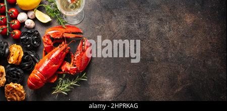 Homard rouge cuit avec ingrédients pour les pâtes et verre de vin de white sur fond sombre. Gastronomie de vacances. Longue bannière avec espace de copie Banque D'Images