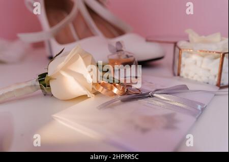 Accessoires de mariée. Anneaux de mariage d'or, boutonnière du marié, pour la mariée, invitation de mariage Banque D'Images