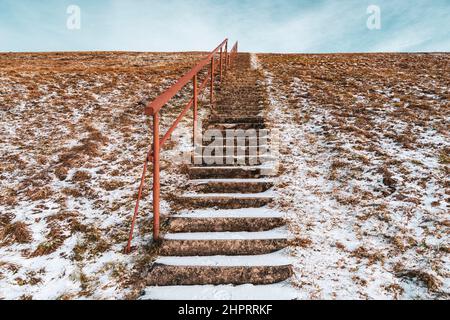 Ciel bleu d'hiver et escaliers s'étendant jusqu'à une colline enneigée.le concept de la croissance de carrière ou la route vers le ciel. Des marches sur une haute colline mènent au ciel. Banque D'Images