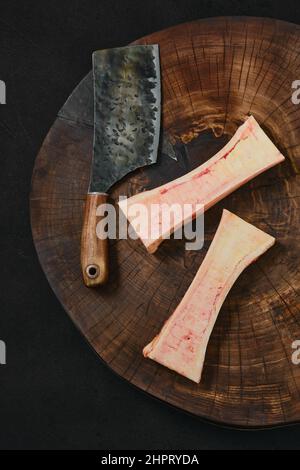 Vue en hauteur de la grande moelle osseuse de bœuf hachée sur la moitié sur une souche de bois Banque D'Images