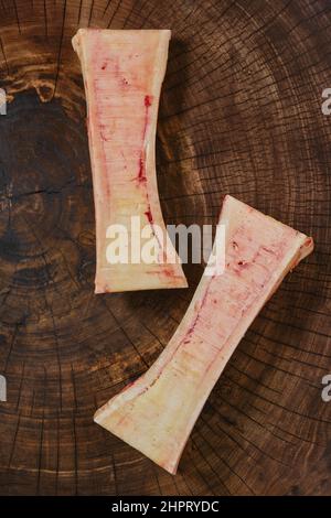Vue en gros plan au-dessus de la tête de la grande moelle osseuse de bœuf hachée sur la moitié sur une souche en bois Banque D'Images