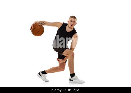 Jeune homme musclé, joueur de basket-ball pratiquant avec le ballon isolé sur fond blanc de studio. Concepts de sport, de mouvement, d'activité. Banque D'Images