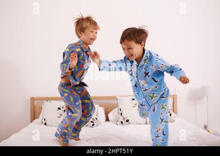 J'ai eu les mouvements comme jagger. Photo de deux petits garçons sautant sur le lit. Banque D'Images