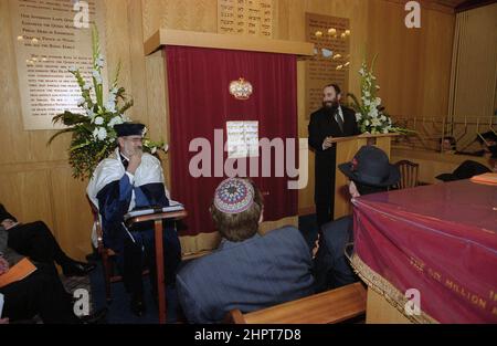 Le Grand Rabbin Jonathan Sacks a été l'invité d'honneur pour la célébration du 25th anniversaire de la Congrégation hébraïque de Solihull. Au cours de sa visite, il a rencontré des enfants dans le salon d'une famille de la congrégation. Il parle officieusement aux jeunes enfants juifs de leur travail réalisé au Cheder de la synagogue (salle de classe), regarde le ministre de la congrégation, Rabbi Yehuda Pink. Il a pris la parole lors de la commémoration le 27th octobre 2002.le maire de Solihull Cllr. Kate Wild a assisté et a reçu un bouquet de l'élève de Cheder de 13 ans Zipporah Gershon Banque D'Images