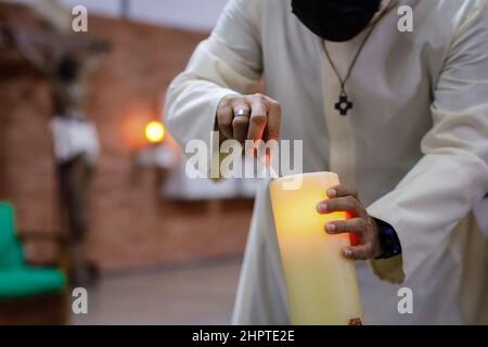 Caracas, Venezuela. 13th févr. 2022. Un prêtre allume une bougie avant un service dans une église au sud de la ville. Credit: Jesus Vargas/dpa/Alamy Live News Banque D'Images