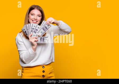 Fille sûre d'elle-même montrant des dollars de ventilateur en argent. Monnaie papier. Femme souriante prend plusieurs billets de ventilateur et sourit. Revenu passif et richesse. Remboursement. Dépôts, placements, transactions. Banque D'Images