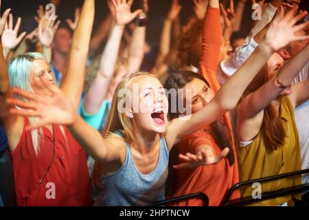 Pris dans la vibe. Un grand groupe de fans crient à un concert de rock. Banque D'Images