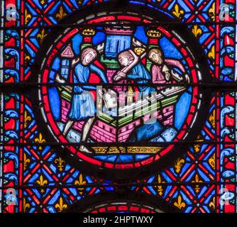 Bâtiment du château en vitraux : détail d'une ancienne fenêtre en vitraux à Sainte Chapelle. Trois hommes construisent le parapet au sommet d'un château. Banque D'Images