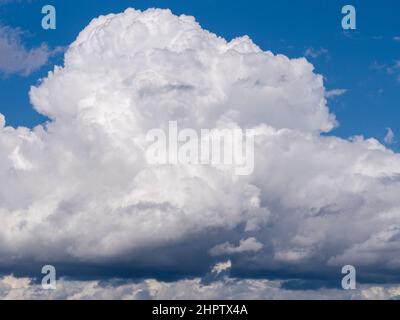 Construction d'un nuage de tempête : un bâtiment de nuages de cumulus de lage au-dessus de la rivière des Outaouais. Un ciel bleu vif au-dessus, un gris foncé au-dessous. Banque D'Images