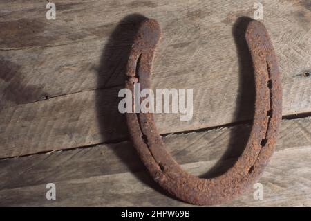 Fer à cheval avec fond en bois et lumière naturelle, espace de copie dans les parties de l'image, concept de ferme. Banque D'Images