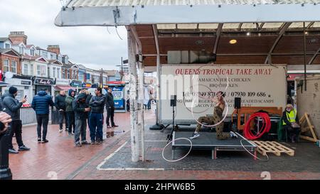 Une femme hola des cerceaux et des danses à Queens Market, Londres Banque D'Images