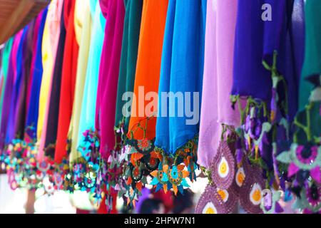 Foulards en soie faits main ou en dentelle à aiguille colorés alignés sur un cintre de corde dans le bazar de femme producteur à Odemis, Izmir.Superbes mousselines de style moderne. Banque D'Images