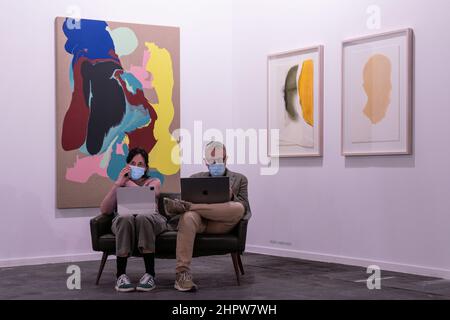 Madrid, Espagne. 23rd févr. 2022. Le personnel de la galerie a vu assis travailler sur leurs ordinateurs portables lors de l'édition 41 d'ARCO.ARCO Madrid est le salon international de l'art contemporain qui, depuis 1982, a été l'une des principales plates-formes du marché de l'art et une pièce essentielle dans le circuit international consacré à la promotion et à la diffusion de la création artistique. Crédit : SOPA Images Limited/Alamy Live News Banque D'Images