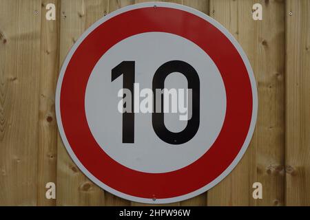 Panneau de signalisation rouge, blanc et noir 'vitesse limite 10 km/h' vissé sur une clôture en bois (image horizontale), Hildesheim, Basse-Saxe, Allemagne Banque D'Images