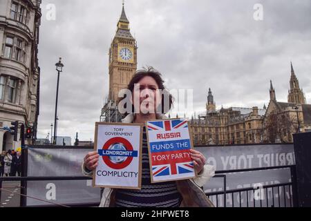 Londres, Royaume-Uni. 23rd février 2022. Un manifestant sur la place du Parlement tient un écriteau suggérant que la Russie finance le Parti conservateur. Des manifestants anti-conservateurs se sont rassemblés à Westminster alors que Boris Johnson était confronté à des QPM. Credit: Vuk Valcic/Alamy Live News Banque D'Images