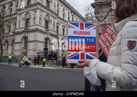 Londres, Royaume-Uni. 23rd février 2022. Un manifestant détient un écriteau suggérant que la Russie finance le Parti conservateur, alors que le cortège de Boris Johnson quitte Downing Street. Des manifestants anti-conservateurs se sont rassemblés à Westminster alors que Boris Johnson était confronté à des QPM. Credit: Vuk Valcic/Alamy Live News Banque D'Images