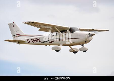 Cessna 172 Skyhawk G-OSPK de Russell Denny dans un concours de bombardement de farine à Elmsett Airfield, Suffolk, Royaume-Uni. Faire tomber un sac de farine de la fenêtre Banque D'Images