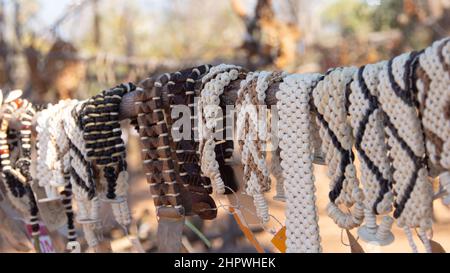 Gros plan d'une rangée de bracelets africains faits de graines, de perles et de bois exposés sur un marché extérieur en Namibie, Afrique Banque D'Images