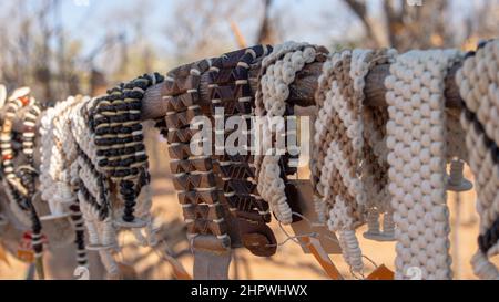 Gros plan d'une rangée de bracelets africains faits de graines, de perles et de bois exposés sur un marché extérieur en Namibie, Afrique Banque D'Images