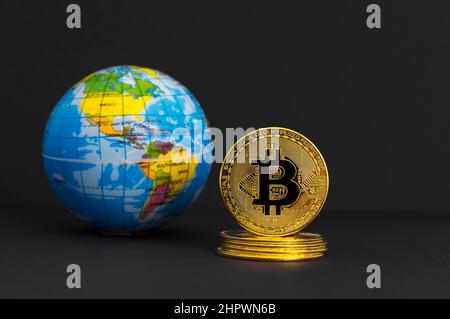 Bitcoin BTC crypto monnaie pièce d'or et globe terrestre, nouveau concept mondial de monnaie virtuelle. Technologie minière ou blockchain Banque D'Images