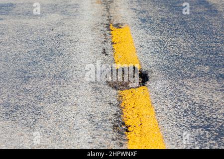 Gros plan de la cagoule, trou de chuckhole, sur la chaussée asphaltée. Concept de réparation, d'entretien et de dommages de rue. Banque D'Images