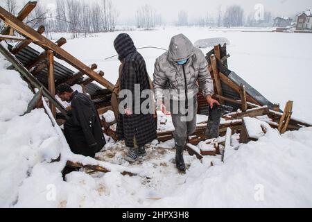 Budgam, Inde. 22nd févr. 2022. Les gens inspectent une maison endommagée au village de Bugam Chadoora. La vallée du Cachemire a subi de fortes chutes de neige, ce qui a conduit à la fermeture de routes dans les zones éloignées, outre le retard de plusieurs vols en provenance de l'aéroport de Srinagar. Les services ferroviaires locaux ont également été suspendus. Crédit : SOPA Images Limited/Alamy Live News Banque D'Images