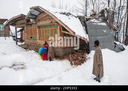 Budgam, Inde. 22nd févr. 2022. Les gens inspectent une maison endommagée au village de Bugam Chadoora.la vallée du Cachemire a reçu de fortes chutes de neige, conduisant à la fermeture de routes dans les zones éloignées outre le retard de plusieurs vols en provenance de l'aéroport de Srinagar. Les services ferroviaires locaux ont également été suspendus. (Photo de Faisal Bashir/SOPA Images/Sipa USA) crédit: SIPA USA/Alay Live News Banque D'Images