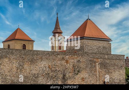 Les tours de Varpalota Hongrie. Tour de château médiéval en forme de deux carrés du château de Thury au toit rouge et tour d'horloge baroque de la commune Banque D'Images