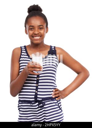 Le lait va m'aider à grandir. Portrait studio d'une jeune fille afro-américaine qui boit un verre de lait isolé sur blanc. Banque D'Images