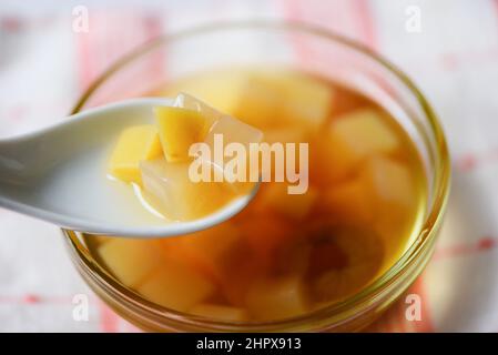 Desserts chinois, mélanger les noix de ginkgo sirop de manioc gelée de noix de coco dans le jus de longan sur un bol en verre, soupe thaïlandaise et chinoise de datte sucreries asiatiques dessert Banque D'Images