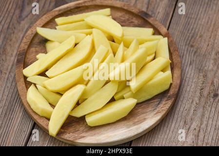 quartiers de pommes de terre frais crus, pommes de terre hachées pour les aliments cuits sur bakrow en bois Banque D'Images