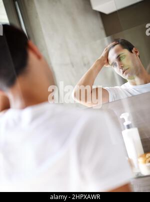 Que dois-je commencer ce matin ? Photo courte d'un jeune homme se regardant dans le miroir. Banque D'Images