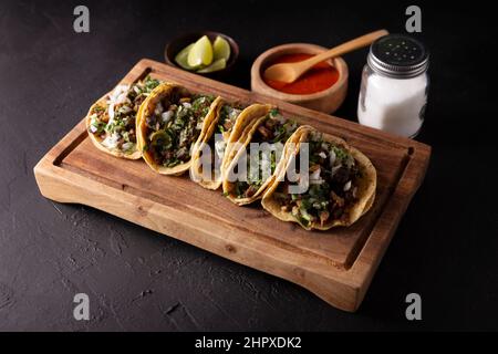 Tacos de Suadero. Viande frite dans une tortilla au maïs. Cuisine de rue de CDMX, au Mexique, traditionnellement accompagnée de coriandre, d'oignon et de sauce rouge épicée Banque D'Images