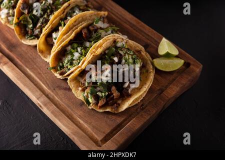 Tacos de Suadero. Viande frite dans une tortilla au maïs. Cuisine de rue de CDMX, au Mexique, traditionnellement accompagnée de coriandre, d'oignon et de sauce rouge épicée Banque D'Images