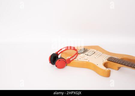 Guitare électrique et casque isolés sur fond blanc Banque D'Images