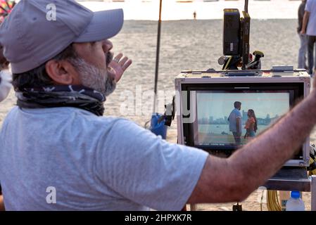 Le producteur de films de Bollywood filme en extérieur et regarde la production à l'aide d'un moniteur. Banque D'Images