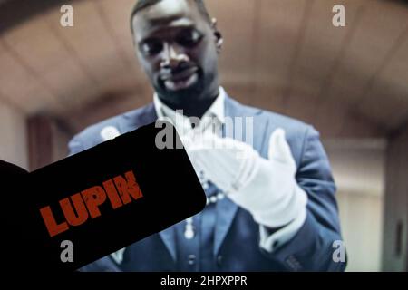 Rheinbach, Allemagne 24 février 2022, le logo de la nouvelle série Netflix « Lupin » sur l'écran d'un smartphone devant le téléviseur Banque D'Images