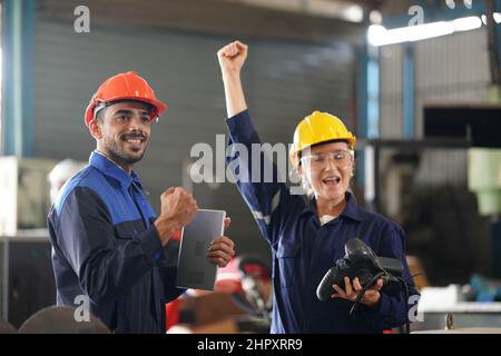 Ingénieur vérifiant le panneau de commande et enseignant le nouveau bras du robot automatique et le fonctionnement de la machine de commande en usine. Banque D'Images