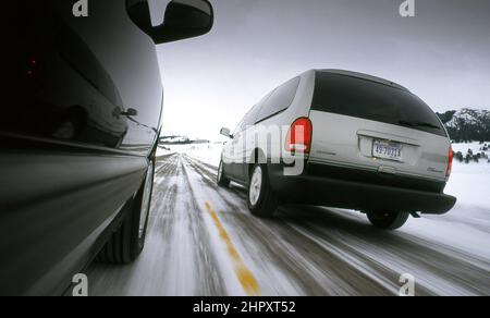 Fourgonnette Dodge Grand Caravan sur route d'hiver dans le parc national de Yellowstone, Montana, États-Unis Banque D'Images