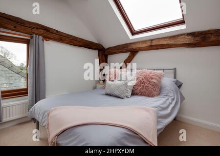 Belle chambre moderne de style grenier dans la vieille maison avec toiture et fenêtre inonder la chambre avec lumière meublée dans blanc, rose saumon et gris fab Banque D'Images