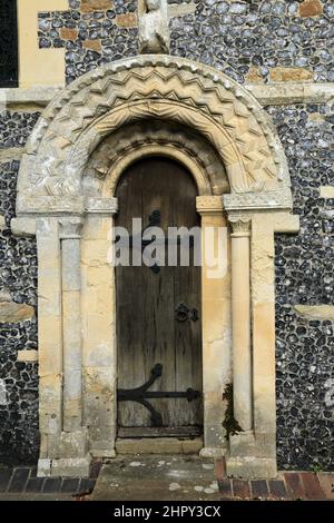 Porte des prêtres avec des sculptures en pierre voûtées au-dessus et des murs de silex dans l'église St Mary - l'architecture normande - Patrixbourne, Canterbury, Kent, Angleterre, Uni Banque D'Images