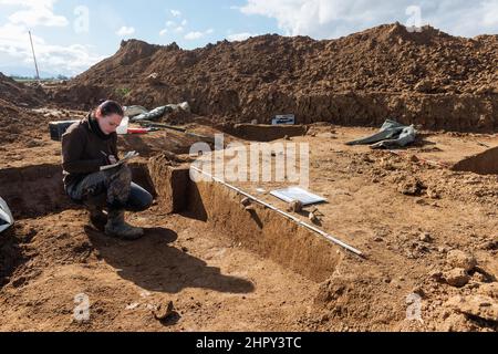 Breisach, Allemagne. 23rd févr. 2022. Un archéologue documente la structure du sol sur un site d'excavation, dans ce cas un fossé sédimenté. Comme des traces de colonies romaines avaient déjà été découvertes à plusieurs reprises sur ce site en 1950s et 60s, des fouilles archéologiques de sauvetage étaient nécessaires pour documenter le patrimoine culturel. Les découvertes fournissent la preuve de l'activité active de peuplement dans la région, avec des traces datant de la période néolithique. Credit: Philipp von Ditfurth/dpa/Alay Live News Banque D'Images