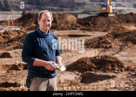 Breisach, Allemagne. 23rd févr. 2022. Horst Esslinger, archéologue de la société e&b MÉlnger, se trouve sur un site d'excavation. Comme des traces de colonies romaines avaient déjà été découvertes à plusieurs reprises sur ce site en 1950s et 60s, des fouilles archéologiques de sauvetage étaient nécessaires pour documenter le patrimoine culturel. Les découvertes fournissent la preuve de l'activité active de peuplement dans la région, avec des traces datant de la période néolithique. Credit: Philipp von Ditfurth/dpa/Alay Live News Banque D'Images