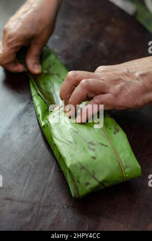 Femme indigène qui cuisine typiquement colombienne et mexicaine plat traditionnel appelé tamal Banque D'Images