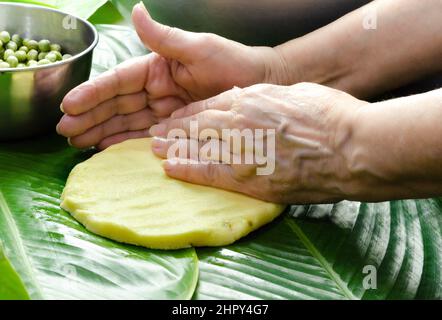 Femme indigène qui cuisine typiquement colombienne et mexicaine plat traditionnel appelé tamal Banque D'Images