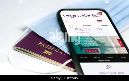 Londres, Royaume-Uni, juillet 2021 : téléphone avec l'application Virgin Atlantic Airlines à l'écran, au-dessus d'un masque de protection et d'un passeport. Sécurité et sécurité des déplacements Banque D'Images