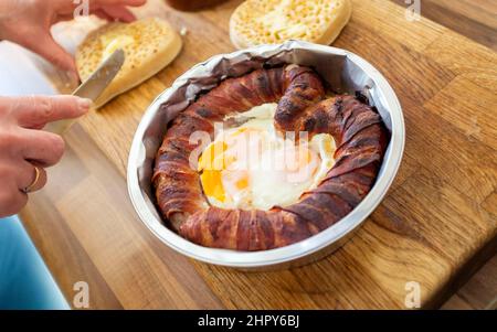 Un petit déjeuner original pour la Saint-Valentin composé de cochons en forme de cœur en couvertures ou de saucisses et de bacon avec œufs frits et crumets beurrés Banque D'Images