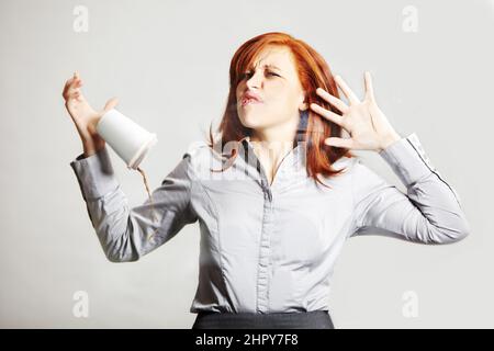 Obstacles invisibles dans le monde des affaires. Une jeune femme d'affaires s'est écrasée contre un mur de verre et a laissé tomber son café. Banque D'Images