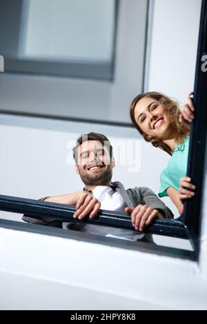 Vous êtes sur le chemin. Photo de deux personnes dans l'escalier souriant tout en vous regardant vers le bas. Banque D'Images